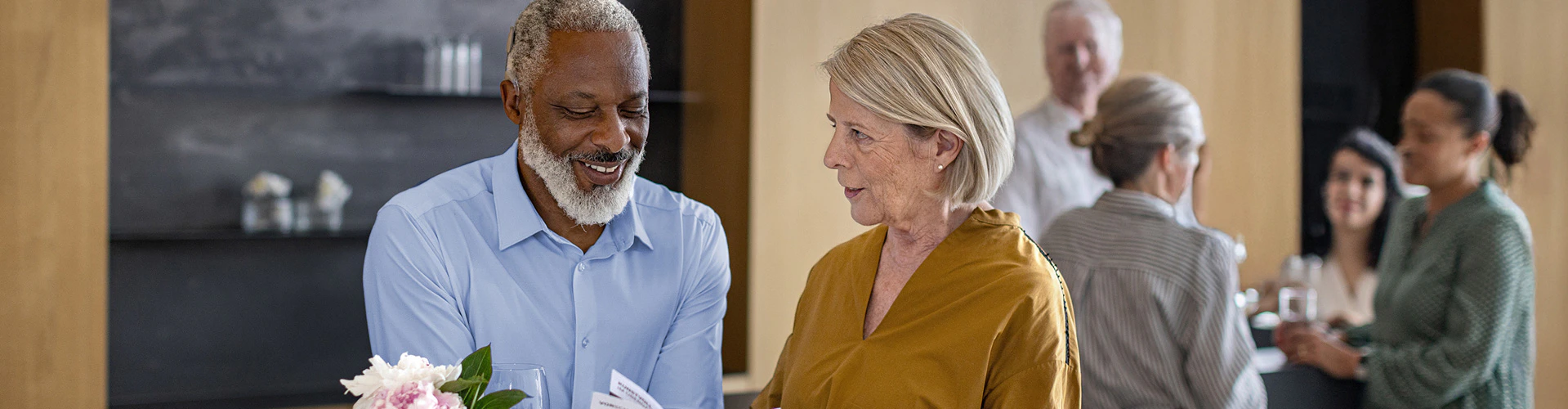An older SONNET 3 user enjoys a conversation at a busy event.