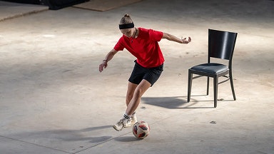 Una adolescente con una camiseta roja juega al fútbol